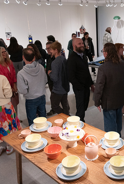 A group of people gathered to view art in the gallery.