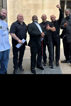 Six men stand smiling outside a courthouse, some raising fists. Left to right: Daniel Rodriguez, Fernando Gomez, Michael McCastle, Gregorio Cardona, Robert Cardona, Lowell Higgins-Bey.