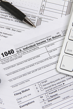 1040 tax form with a pen and computer keyboard.