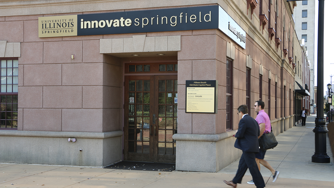Two people walk past the entrance of Innovate Springfield, a UIS innovation hub in downtown Springfield, Illinois.