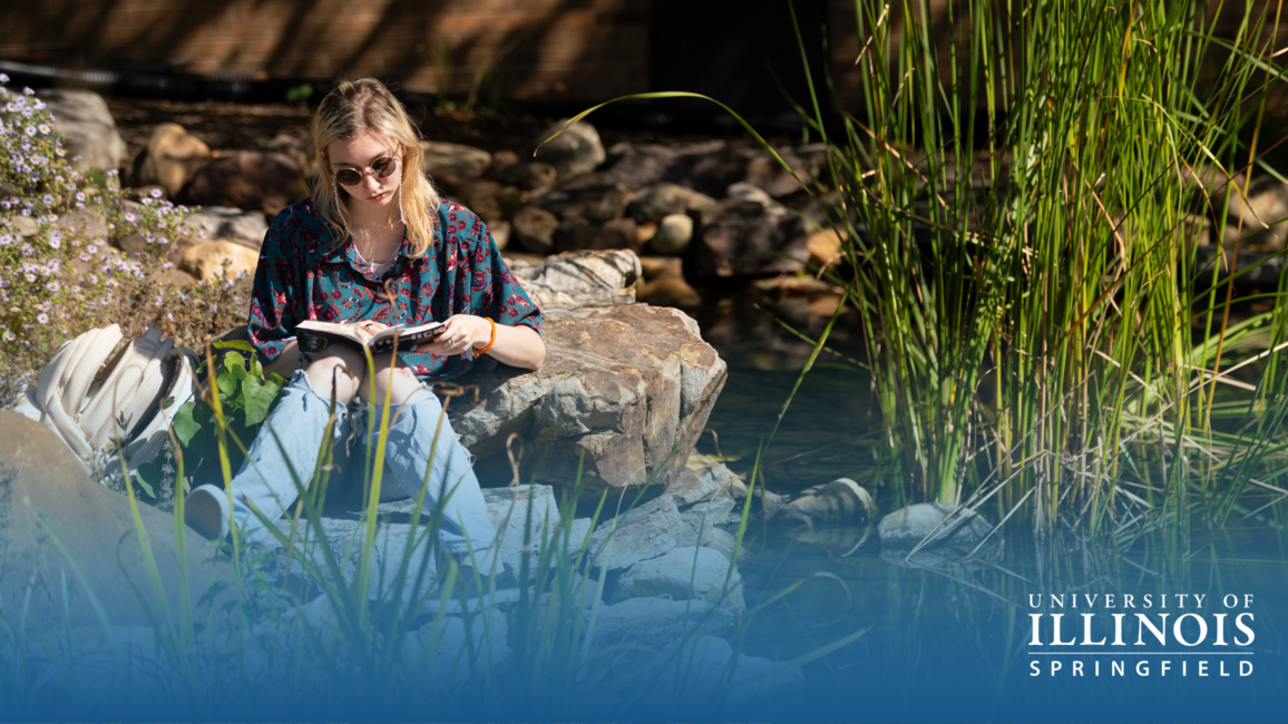 Student reading by the Koi Pond.