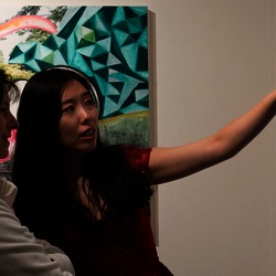 Two women discussing a painting at the UIS Visual Arts Gallery