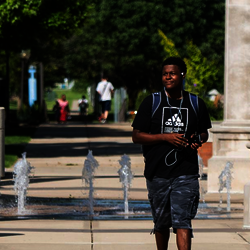 student in front of colonnade