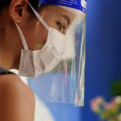 Woman working with mask and face shield