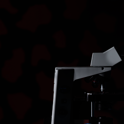student looking at a slide through a microscope