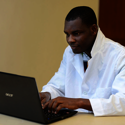 student in lab coat at computer