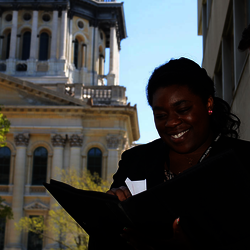two lawmaker students looking over paperwork on the steps of the state capitol