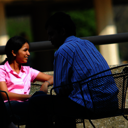 four students sitting out on the quad talking with each other