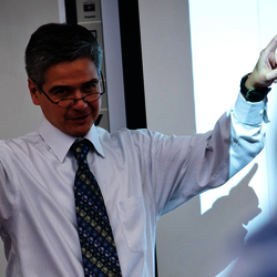 a male teacher teaching at the front of the classroom