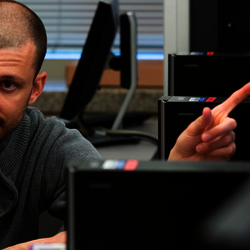 a professor showing a student something on a computer while they sit at a desk