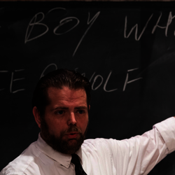 teacher pointing to a chalkboard