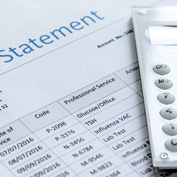 Billing statement with calculator on table.