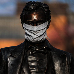 a statute of Abraham Lincoln on campus wearing a mask