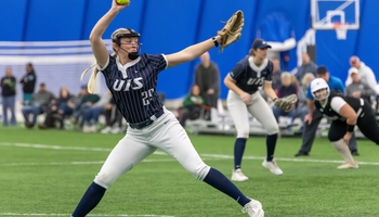 Calista Stahlhut pitching in blue UIS softball uniform