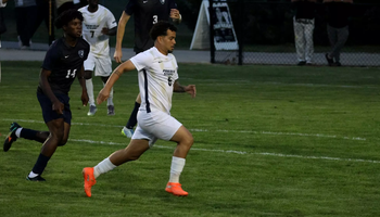 Leo Sanches playing soccer in white UIS uniform