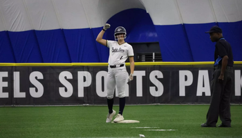 Bailey Masching on second base in white UIS softball uniform