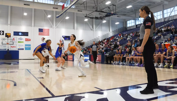 Kennedy Osterman playing basketball in front of home crowd