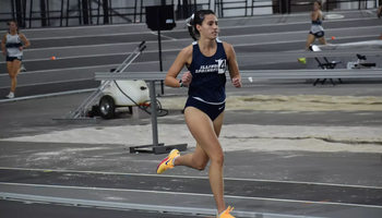Mackenzie Ballard running indoor track in blue UIS uniform