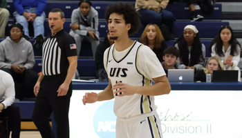 Donaven Younger playing basketball in white UIS uniform