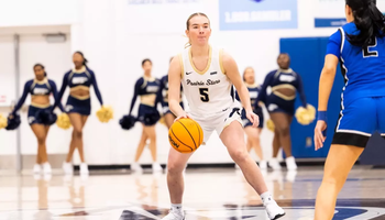 Julia Mingus playing basketball at UIS in white uniform