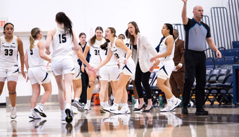 UIS WBB team celebrating on court