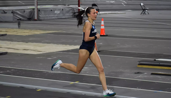 Madelyn Miller-Ross running indoor track in blue UIS uniform