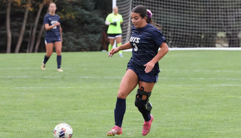 Reese Lowery playing soccer in blue UIS uniform