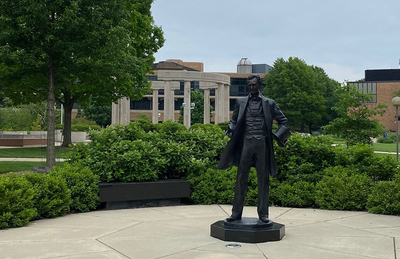 the lincoln statue on campus with a background of the colonnade