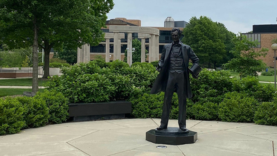 Abraham Lincoln statue on campus is in the foreground and the colonnade is in the background