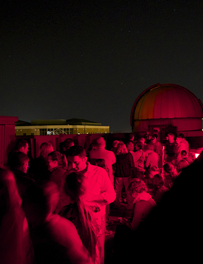 A crowd of people on the roof of Brookens Library for a Star Party.