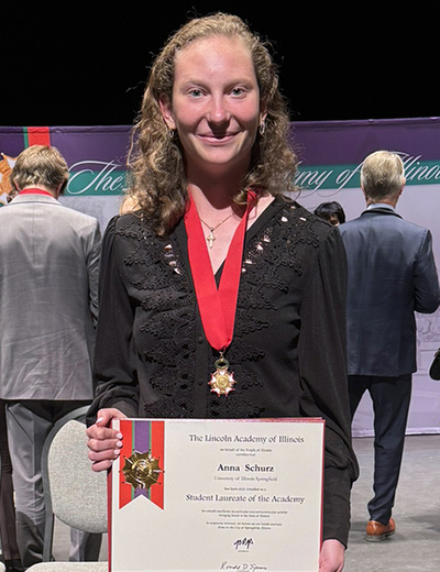 Anna Schurz holding the award