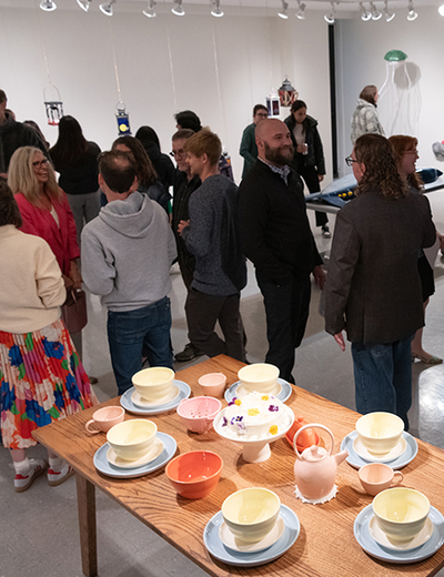 A group of people gathered to view art in the gallery.