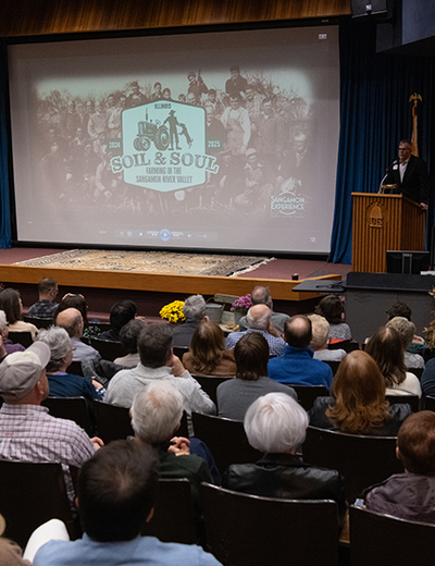 Audience watching the premiere of Soil & Soul at UIS in November 2024, with a speaker at the podium.