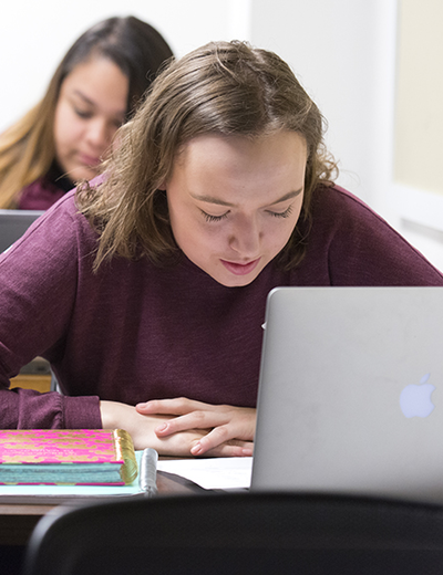 Students in a legal studies class at UIS listen to a lecture and take notes on their laptops.