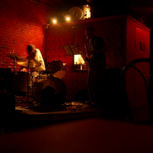 Photograph of a drummer and saxophone player