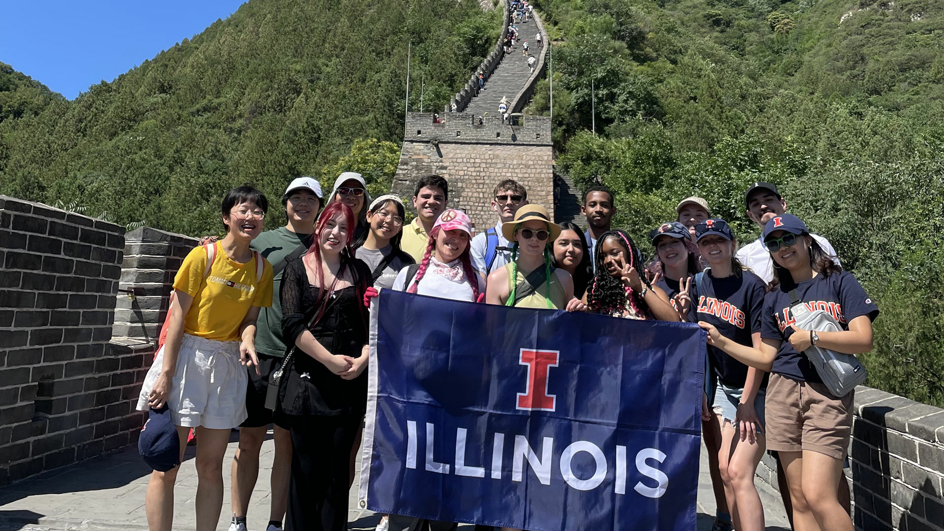 UIS students on the Great Wall of China holding the University of Illinois flag