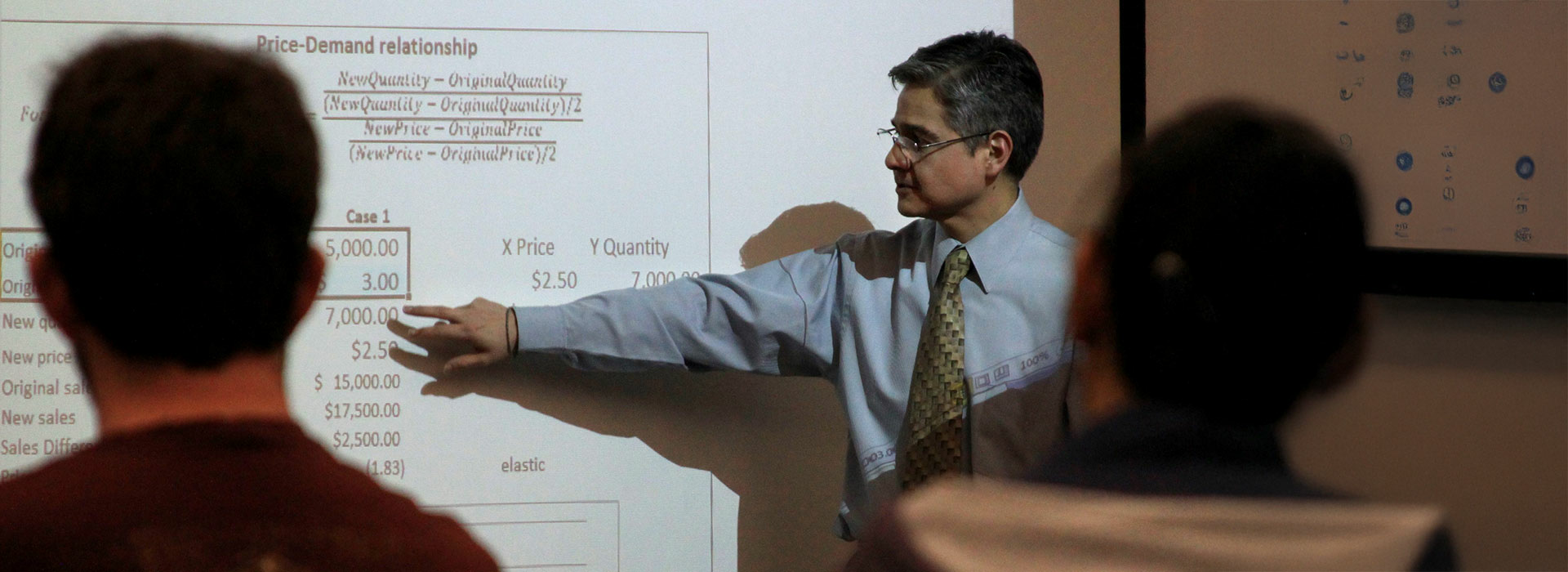 professor teaching in front of whiteboard