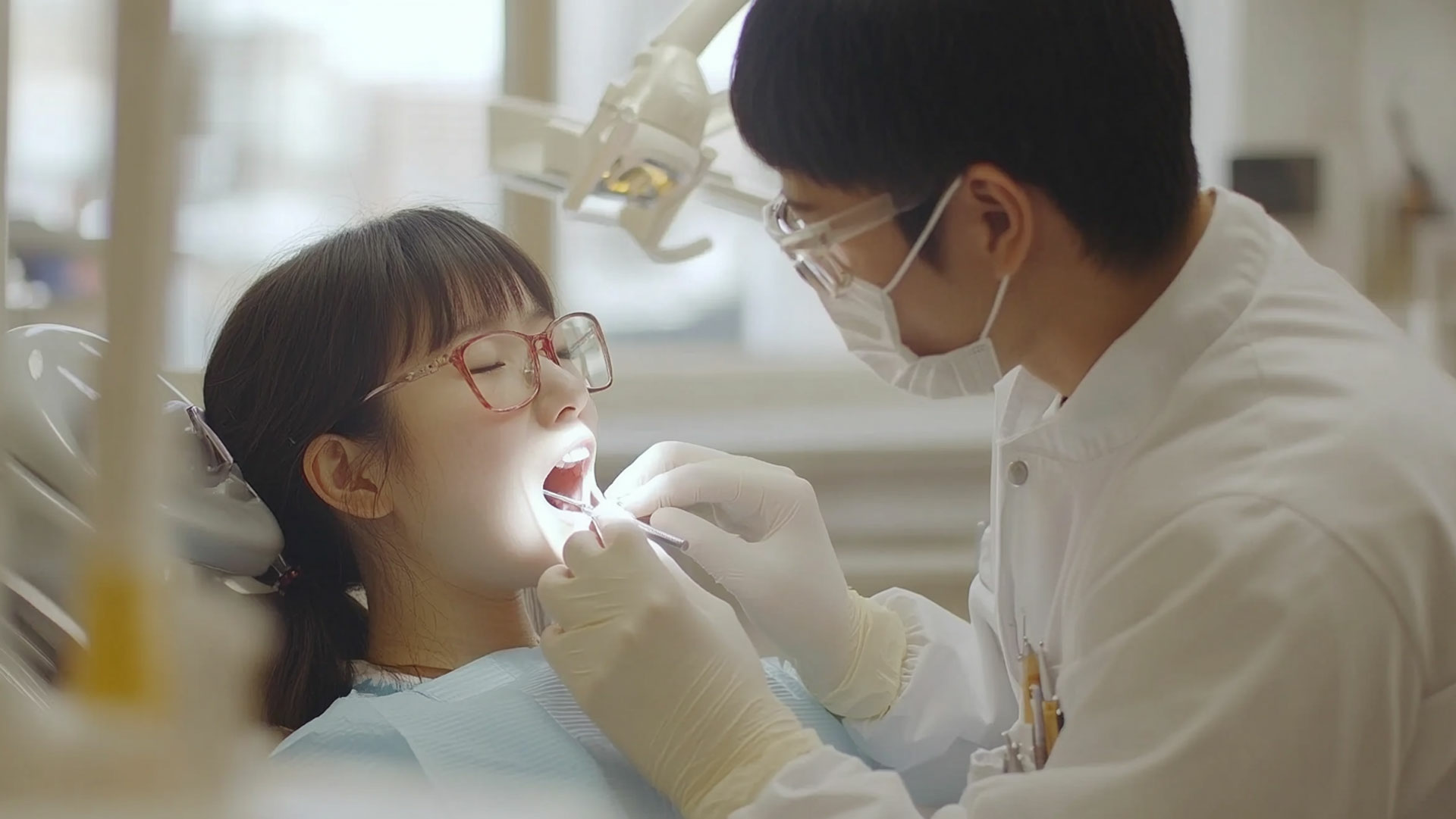 a dentist working on the mouth of a young patient