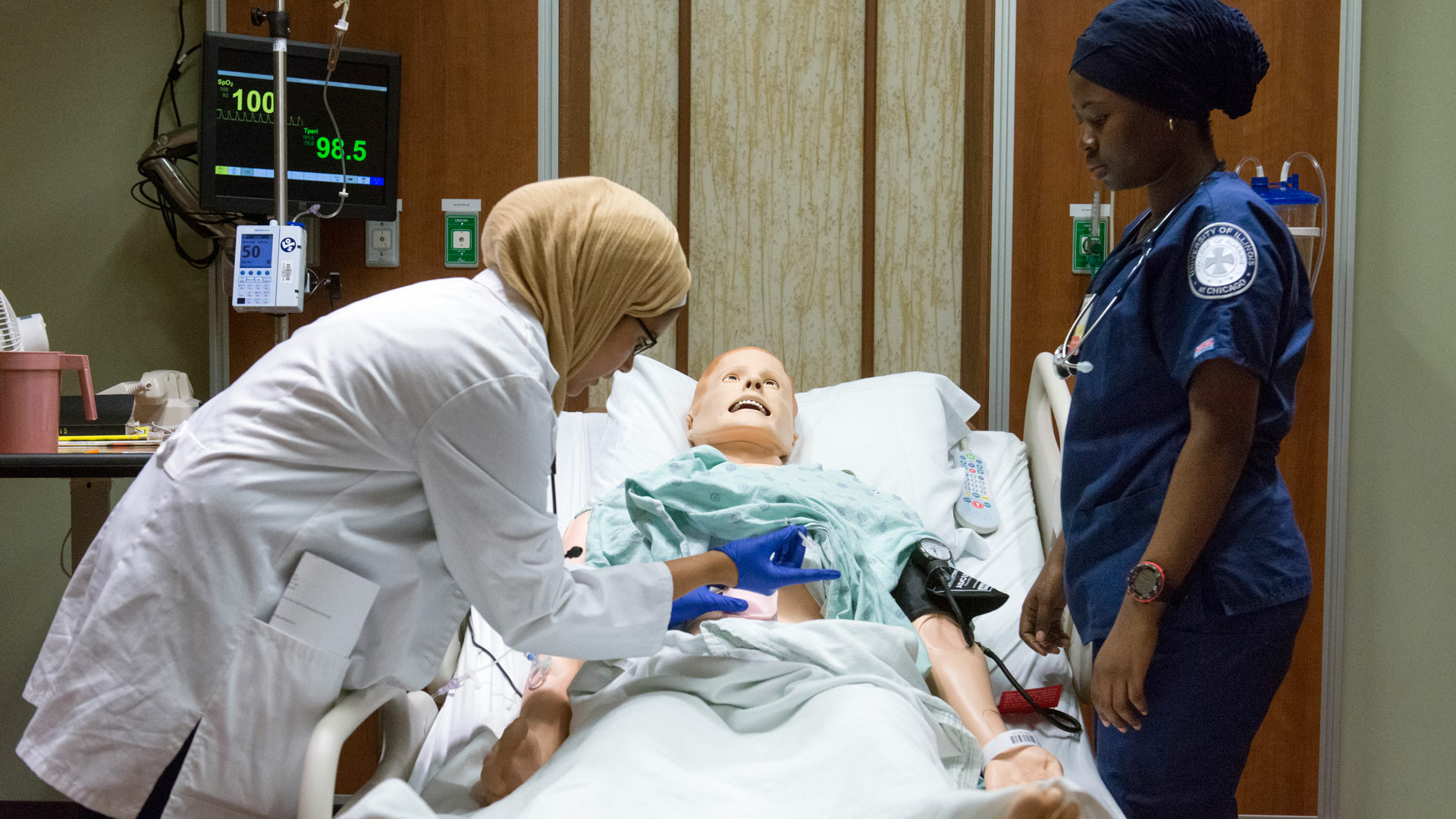 nursing students in the simulation lab looking over a dummy