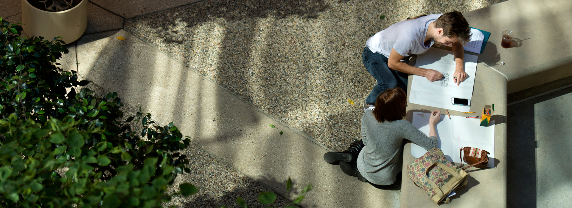 Overhead view of two students working on creative group project together