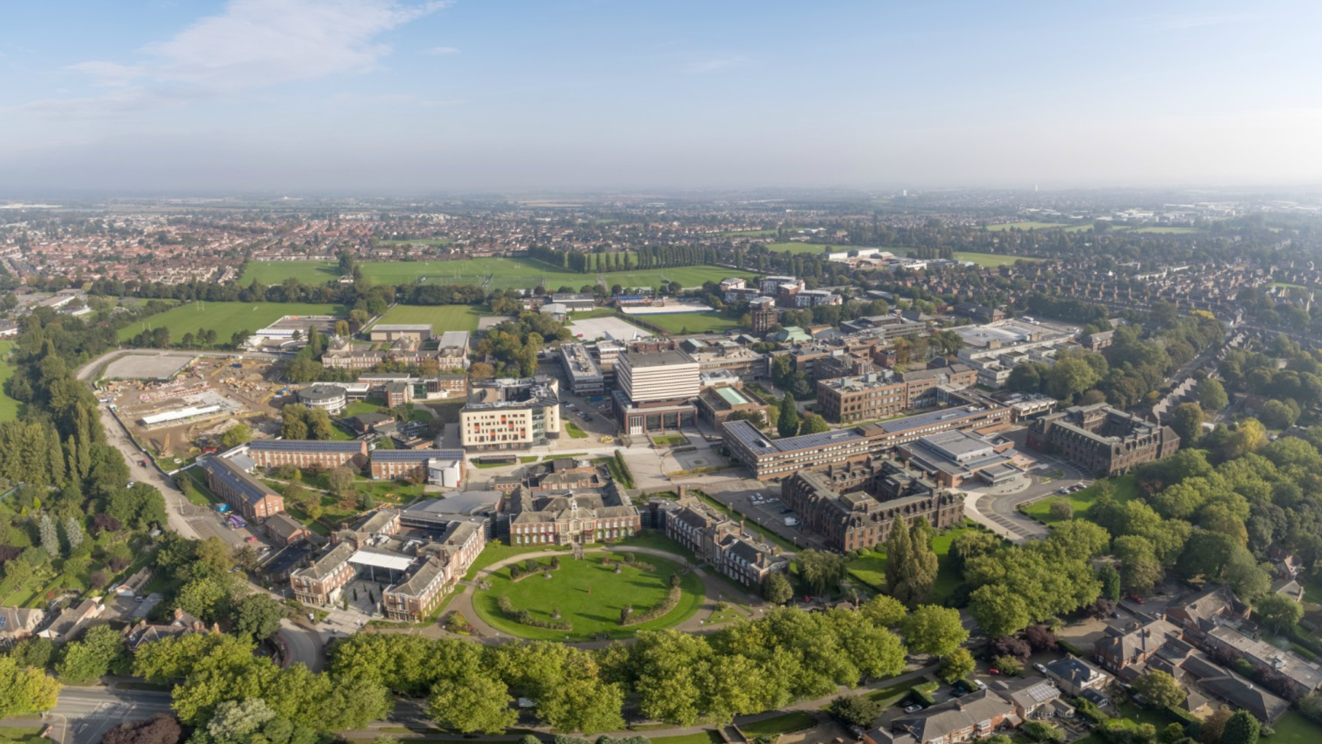 An overview of the University of Hull. There is a large circle of trees that contain numerous buildings within it.