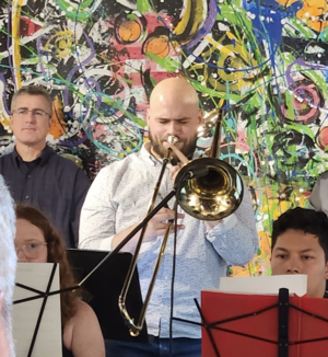 Student Musician performing in a concert holding a trombone.